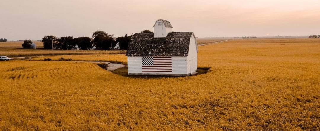 white and black house on brown field under white sky during daytime