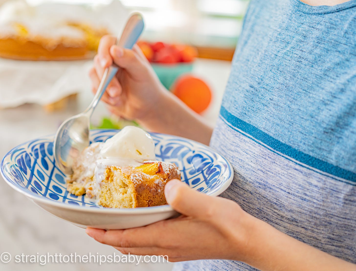 little boy hands holding a slice of peach cake