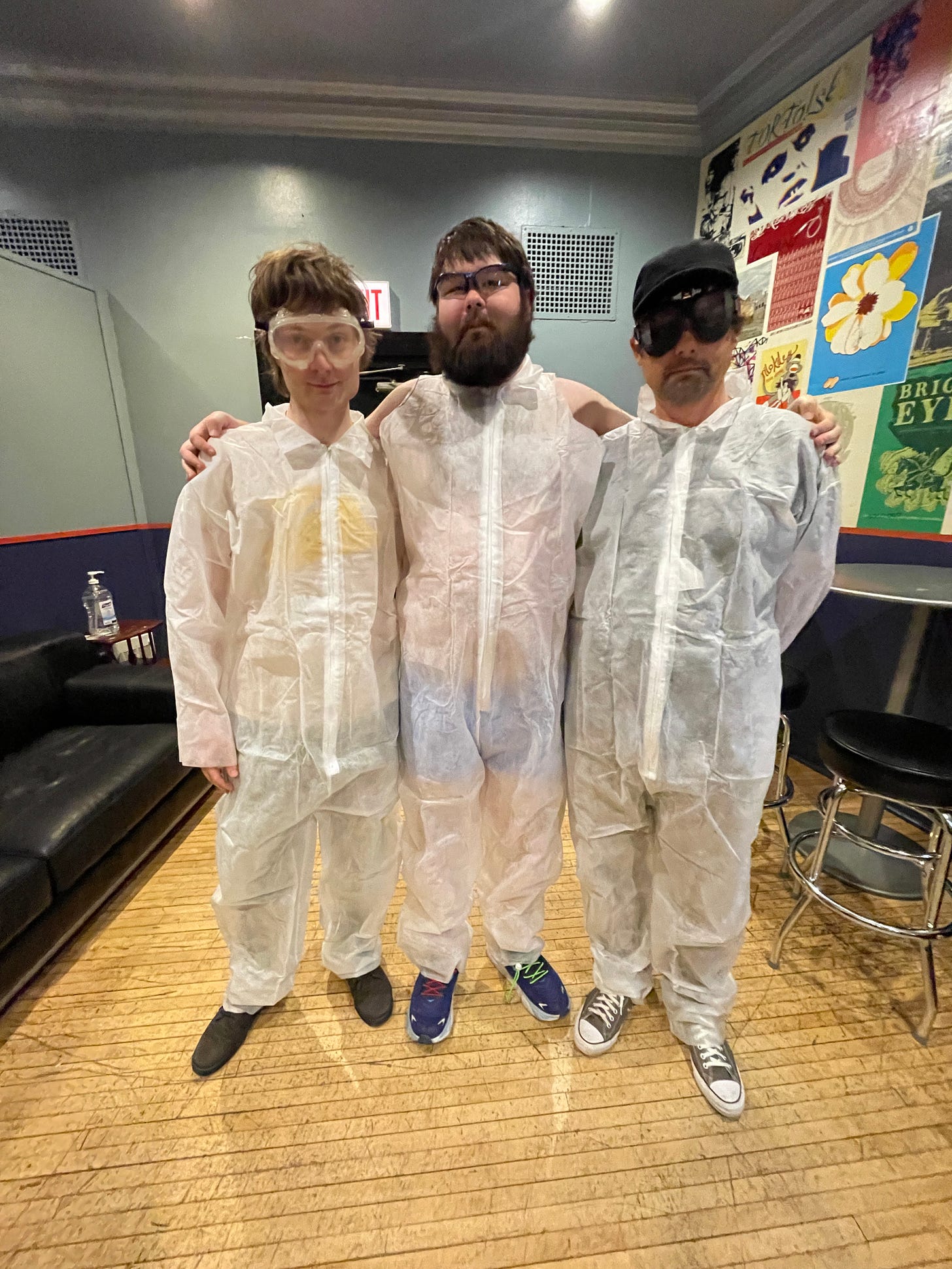 Matt Rizzo, Rick Rizzo and I pose for the camera, standing, wearing disposable white painter suits and goggles, in the dressing room at Metro in Chicago.