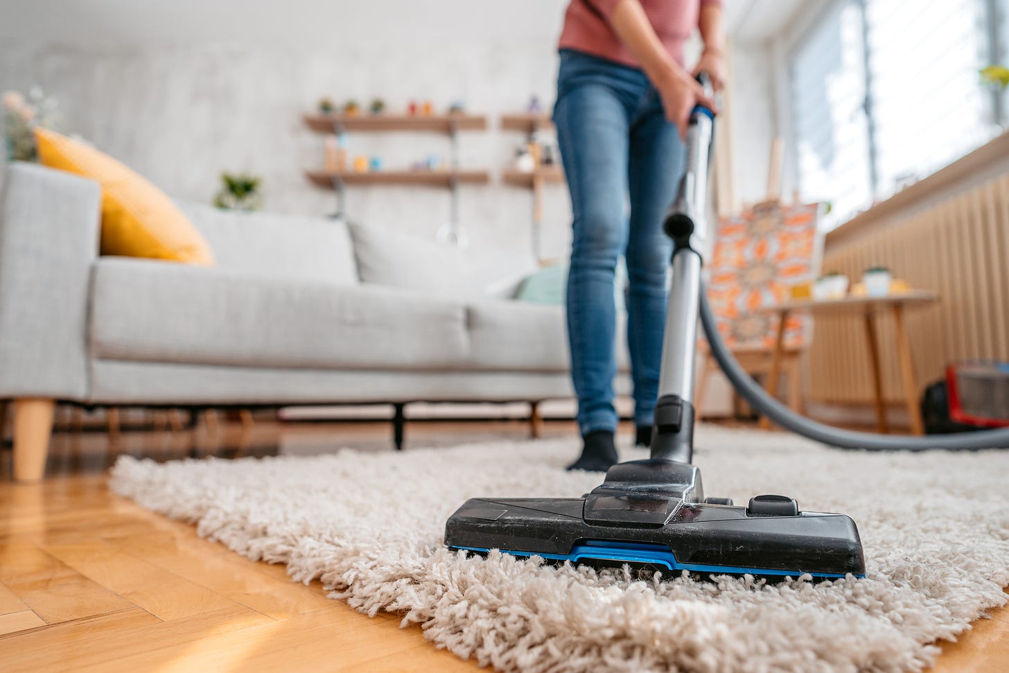 woman vacuuming her apartment. Low angle view.