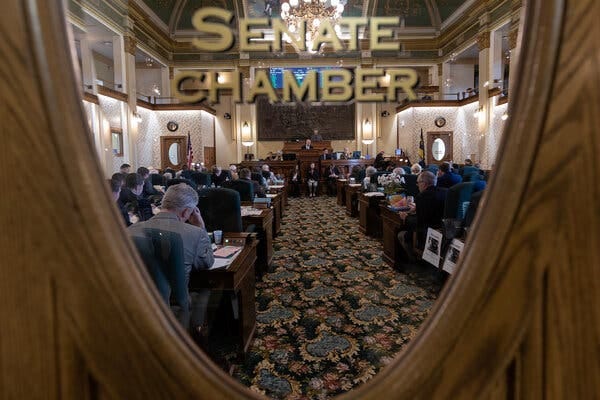 A look through the window of the Montana Senate Chamber with lawmakers seated.