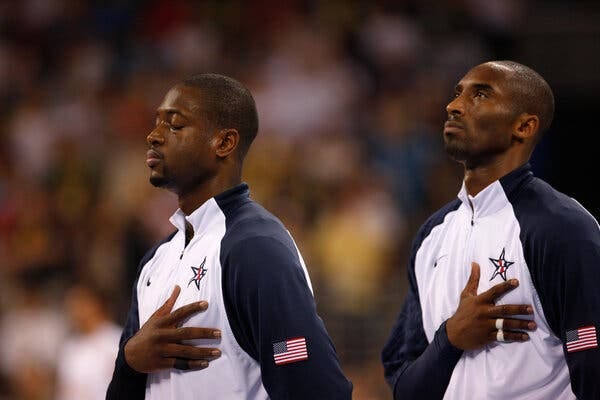 Wade e Kobe com a mão ao peito ouvindo o hino nacional dos EUA