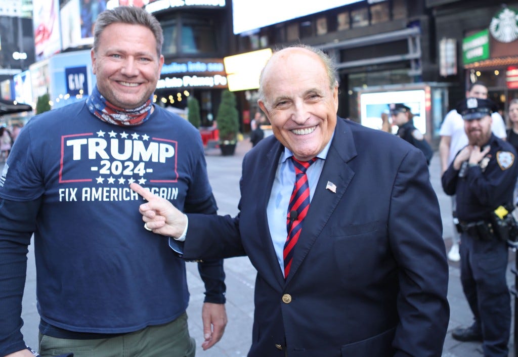 Giuliani poses with a Trump fan in New York City earlier this year.