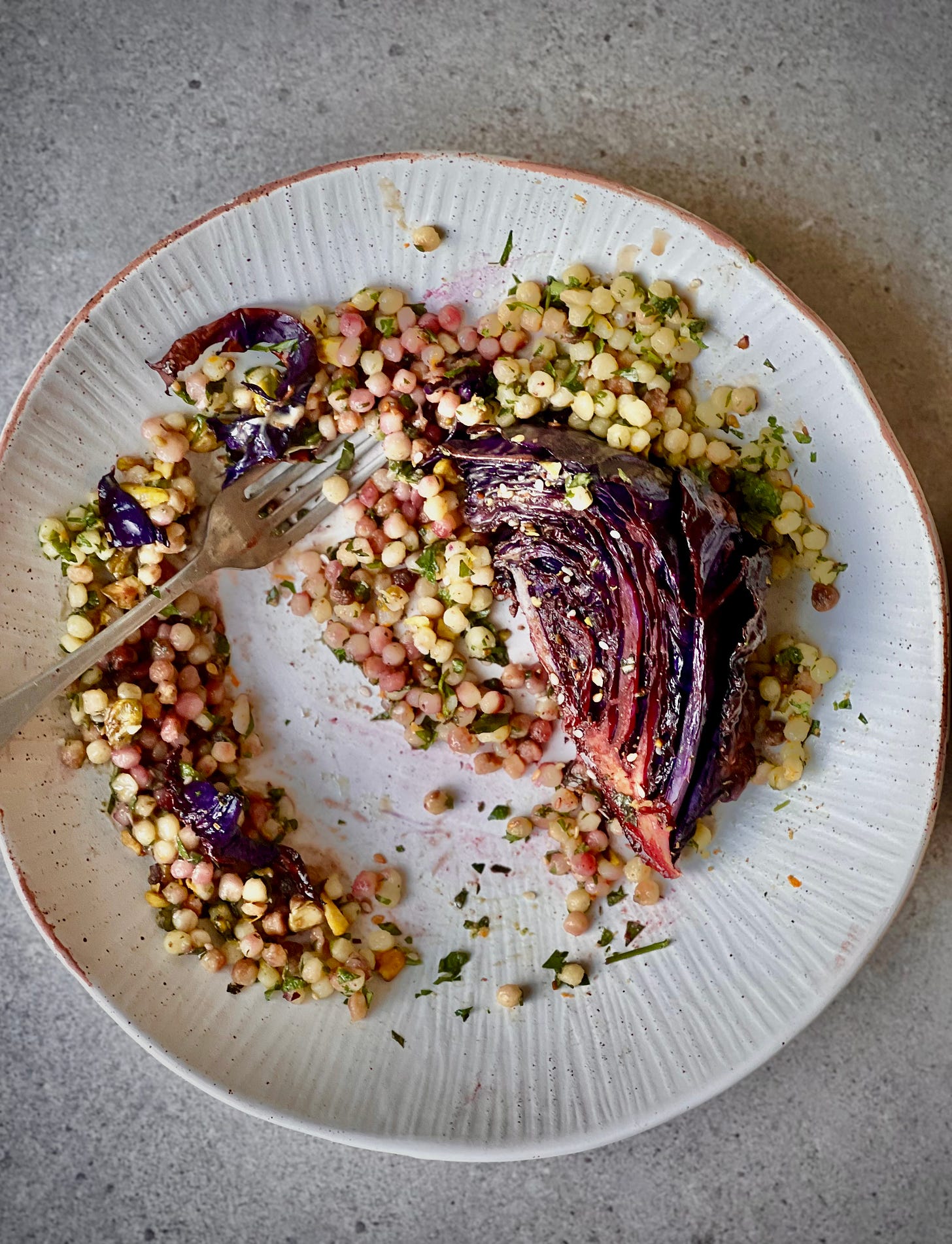 Messy plate of red cabbage and fregola salad