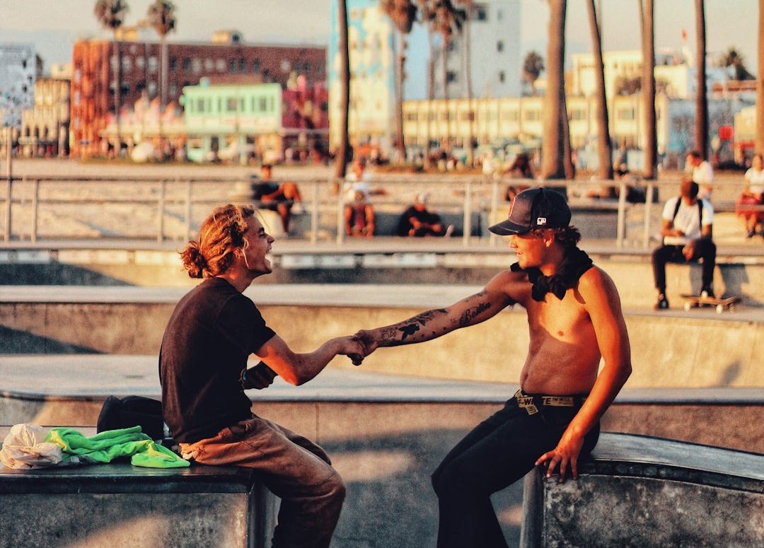 two persons shaking hands in park during daytime