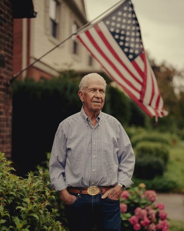 Paul Landis standing in front of his house in Cleveland, with an American flag in the background.