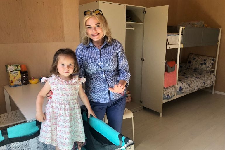 Anna with her daughter, who is wearing a dress.