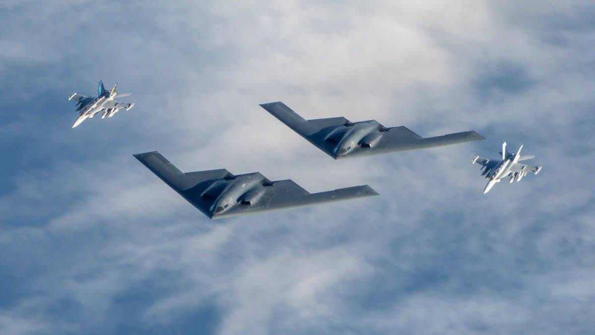 B-2 Bombers flanked by two F-16 fighter jets