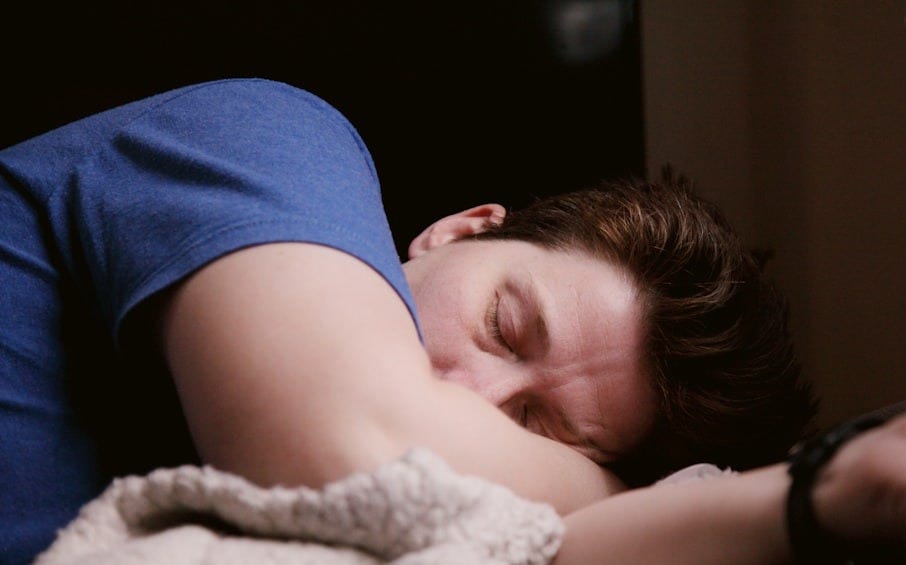 woman in blue shirt lying on bed