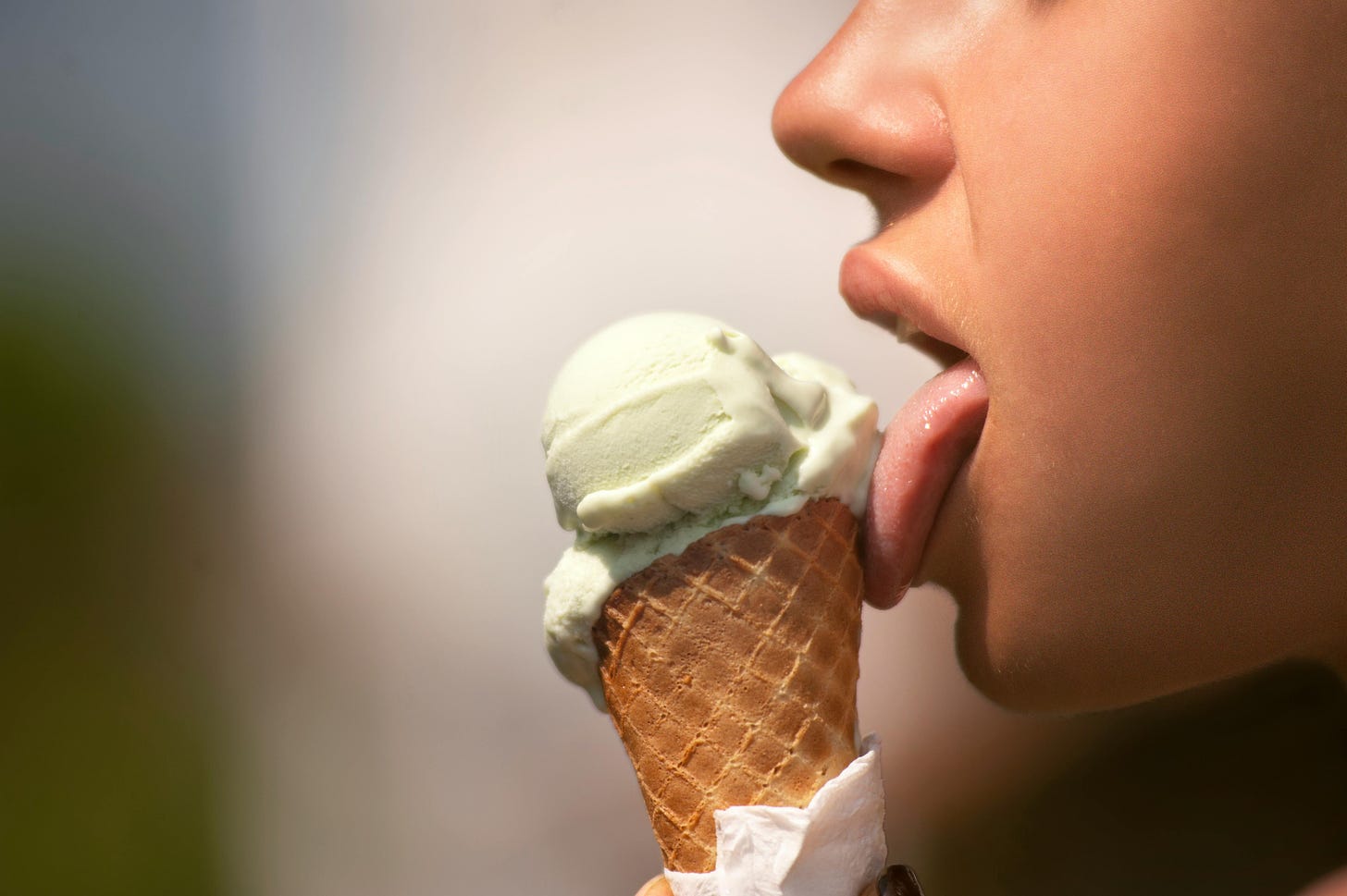 close up of woman's tongue licking ice cream cone