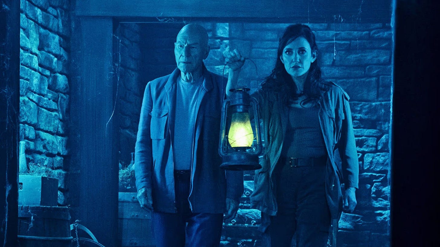 This photo shows Admiral Jean-Luc Picard (played by Sir Patrick Stewart, left) and Tallinn (played by Orla Brady, right) walking through one of Château Picard's basement corridors in their attempt to escape the Borg Queen's commando-drones. Tallinn holds a lantern in this still photograph from "Hide and Seek," Star Trek: Picard Season 2's ninth episode. This photo shows Admiral Jean-Luc Picard (played by Sir Patrick Stewart, left) and Tallinn (played by Orla Brady, right) walking through one of Château Picard's basement corridors in their attempt to escape the Borg Queen's commando-drones. Tallinn holds a lantern in this still photograph from "Hide and Seek," Star Trek: Picard Season 2's ninth episode.