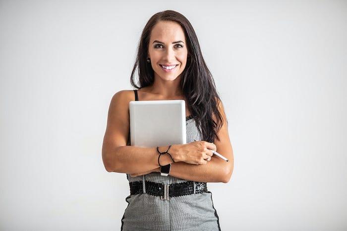 A content creator holding a laptop. A content creator holding a laptop.