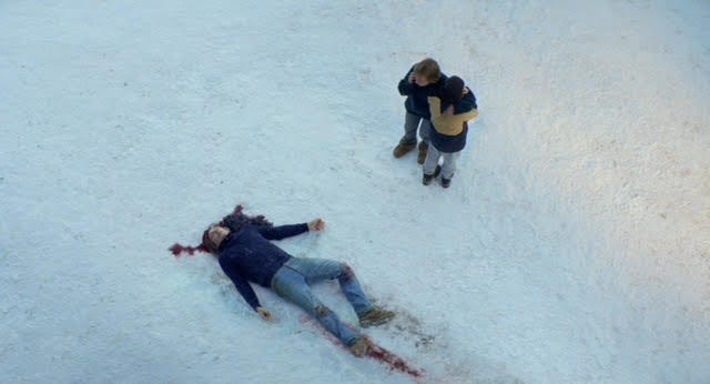 A screenshot from the film Anatomy of a Fall showing the body of the husband after his fatal fall with the wife and son looking on
