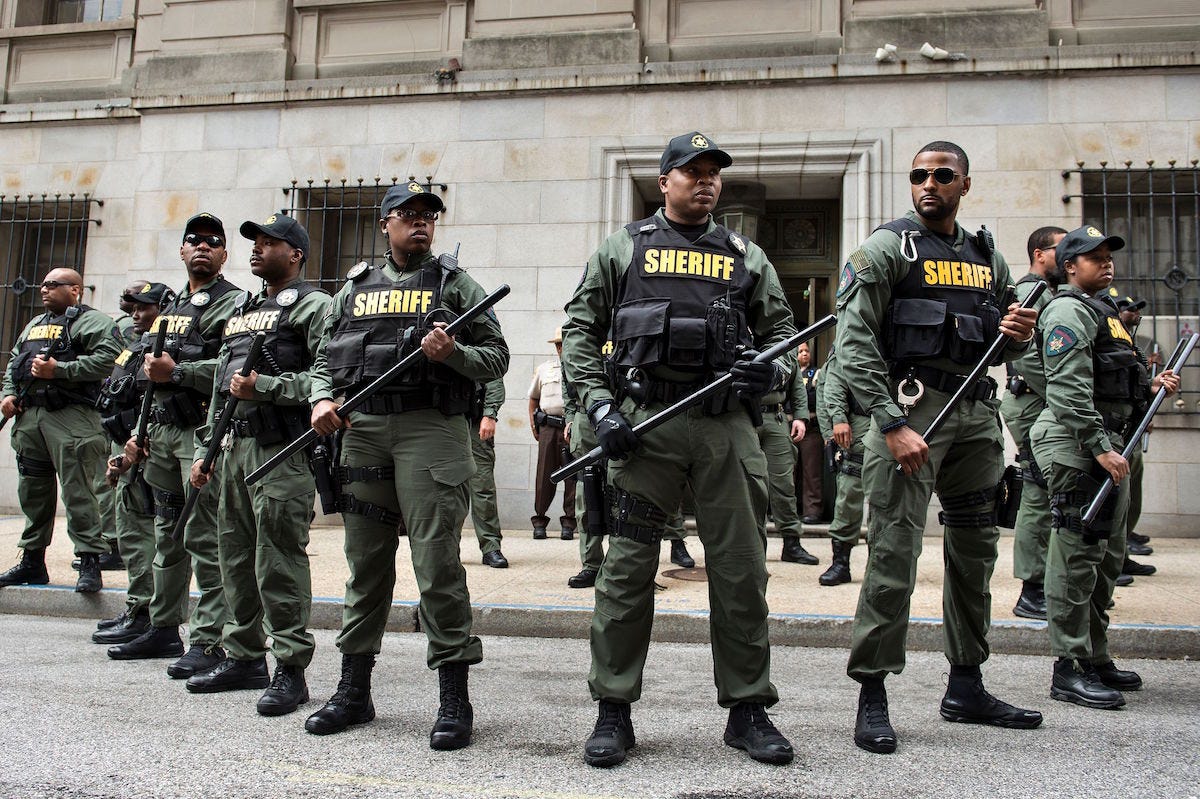 TOPSHOT - Baltimore County Sheriffs officers gather after Baltimore Officer Caesar Goodson Jr. was acquitted of all charges in his murder trial for the death of Freddie Gray at the Mitchell Court House June 23, 2016 in Baltimore, Maryland. Goodson, who drove the van in which Freddie Gray, a young African American, was transported before he died was acquitted of all charges including second degree murder and manslaughter. / AFP / Brendan Smialowski (Photo credit should read BRENDAN SMIALOWSKI/AFP/Getty Images)