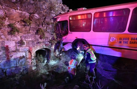 Firefighters stabilize a UC Santa Cruz loop bus after it crashed Dec. 12, resulting in five passengers and the driver being transported to hospitals with injuries. (Shmuel Thaler -- Santa Cruz Sentinel)