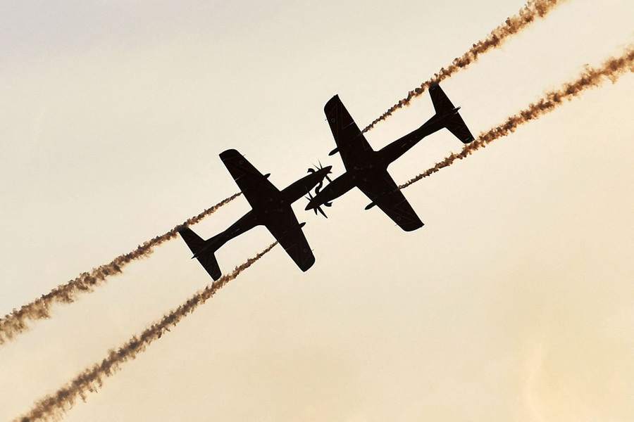 A view of two small aerobatic planes flying toward each other.