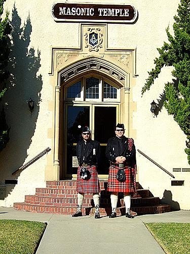 Michael R. MacFarlane (the head of the Clan MacFarlane) and Jim Hoerricks (of the Clan MacFarlane and Michael’s ghillie), Knights of St. Andrew of Scotland, attired in MacFarlane Modern tartan, formal wear. Pictured in front of a Masonic Lodge.