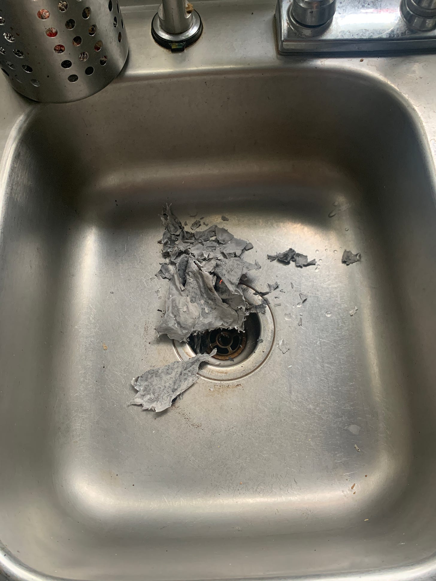 Ashes sit in the bottom of a stainless steel sink