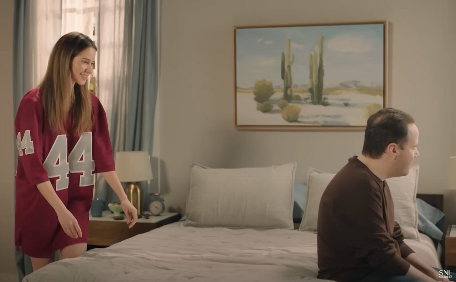 A woman wearing a generic men's football jersy with her male partner A woman wearing a generic men's football jersy with her male partner