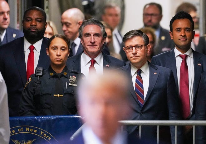 (L-R) US Representative Byron Donalds, Republican of Florida, Governor of North Dakota Doug Burgum, US Speaker of the House Mike Johnson, and former presidential candidate Vivek Ramaswamy listen as former President Donald Trump speaks to reporters as he arrives to attend his trial for allegedly covering up hush money payments linked to extramarital affairs, at Manhattan Criminal Court in New York City, on May 14, 2024.