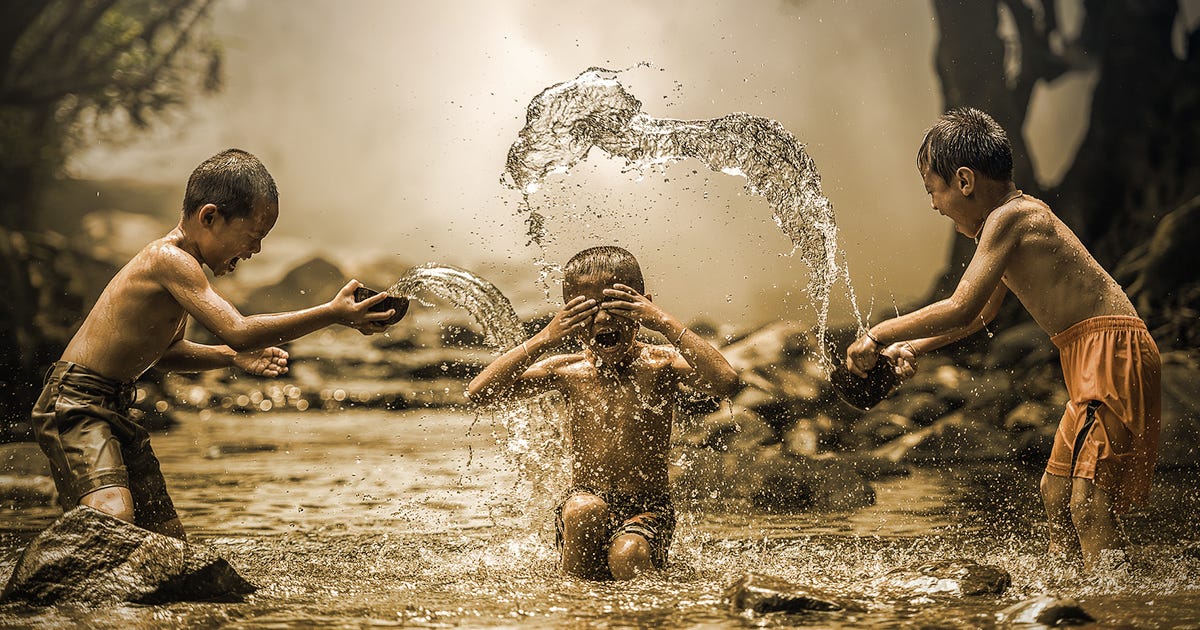 Boys playing outside in a river