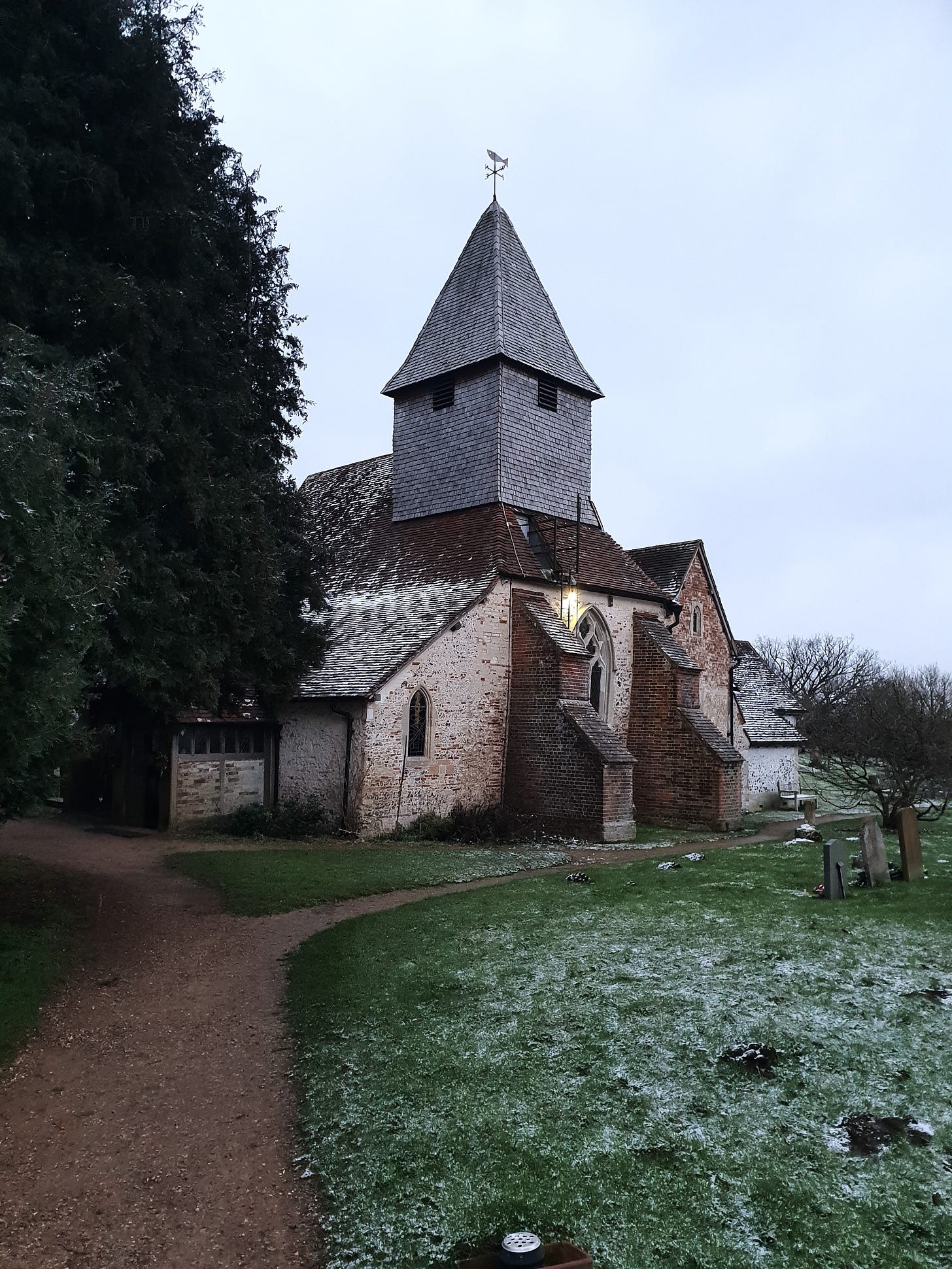 An English country church with a dusting of snow of the rooftop