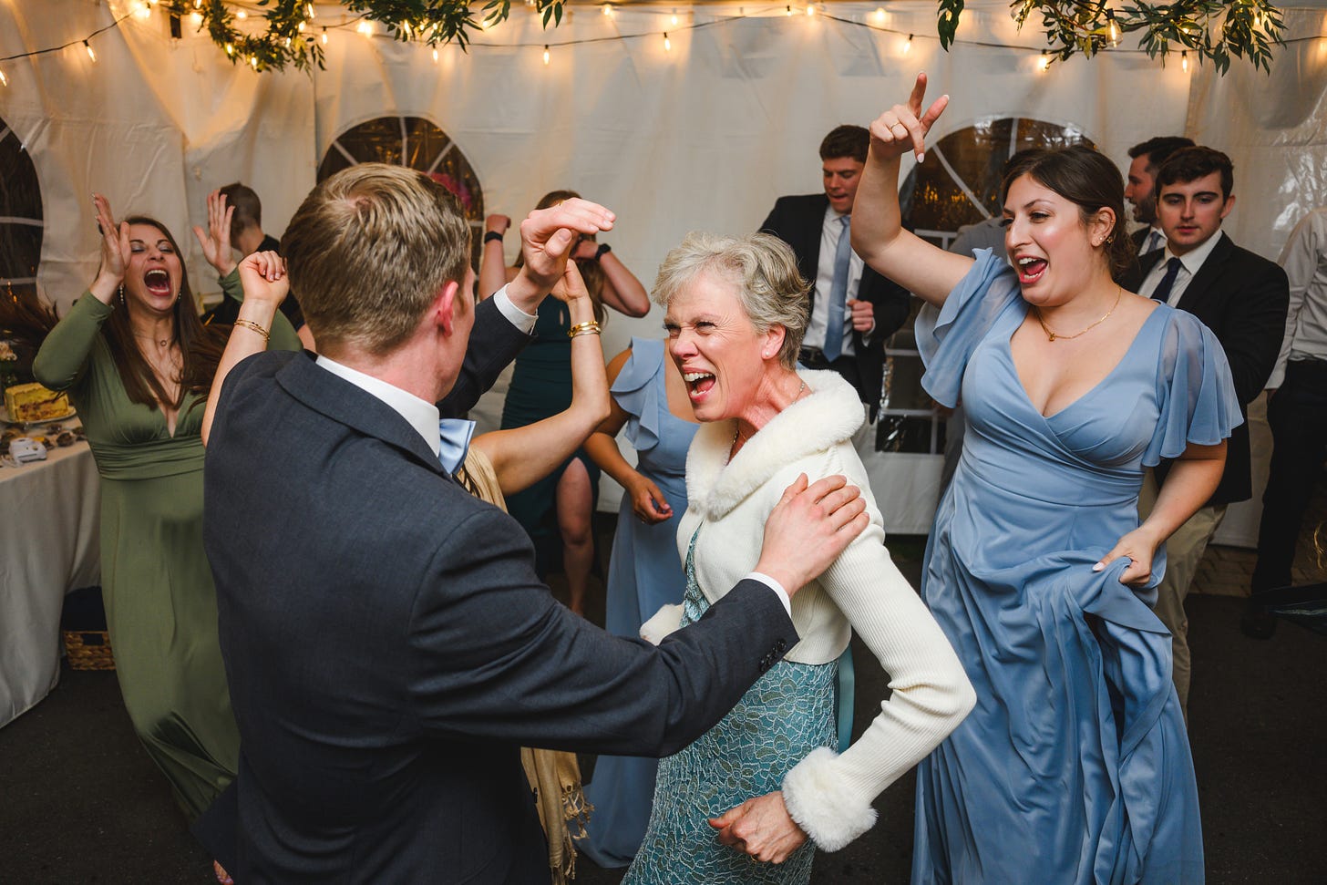 A groom and his mother enthusiastically dancing