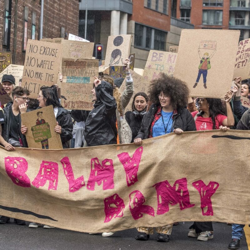Young people with significant MH experiences - the Balmy Army - marched through central Manchester in July 2023 to raise awareness around the broken mental healthcare system and use art to propose new solutions.