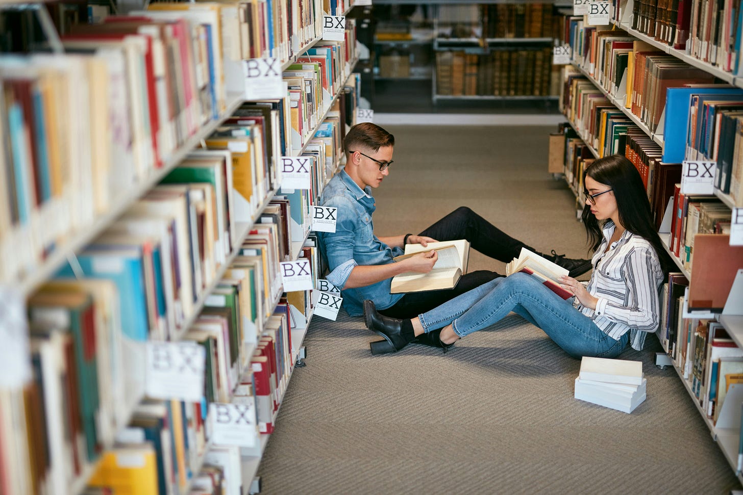 Two people reading in a library