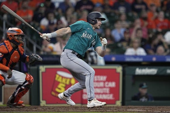 Seattle Mariners' Jarred Kelenic, right, hits a two-run double during the fourth inning of a baseball game against the Houston Astros, Sunday, July 9, 2023, in Houston. (AP Photo/Kevin M. Cox)