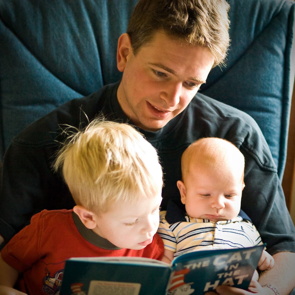 A man reads The Cat and the Hat to two young boys.