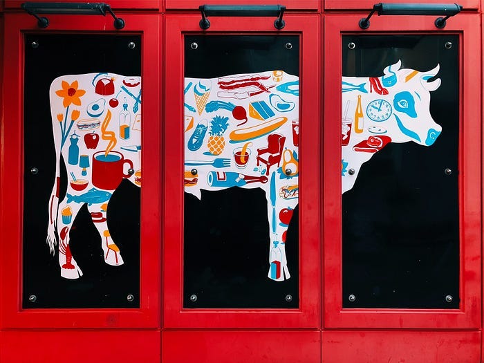 drawing of a cow, framed with three red windows