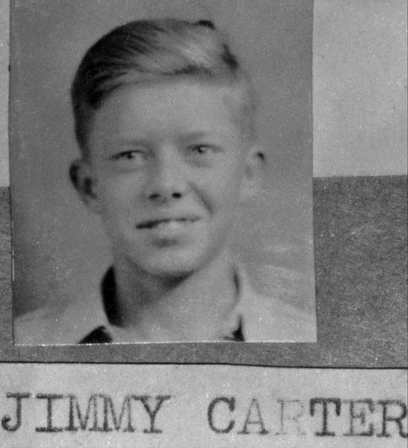 Black and white school picture of Jimmy Carter as a young boy, smiling at camera.