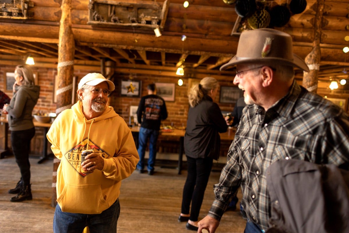 Two men smile while talking.