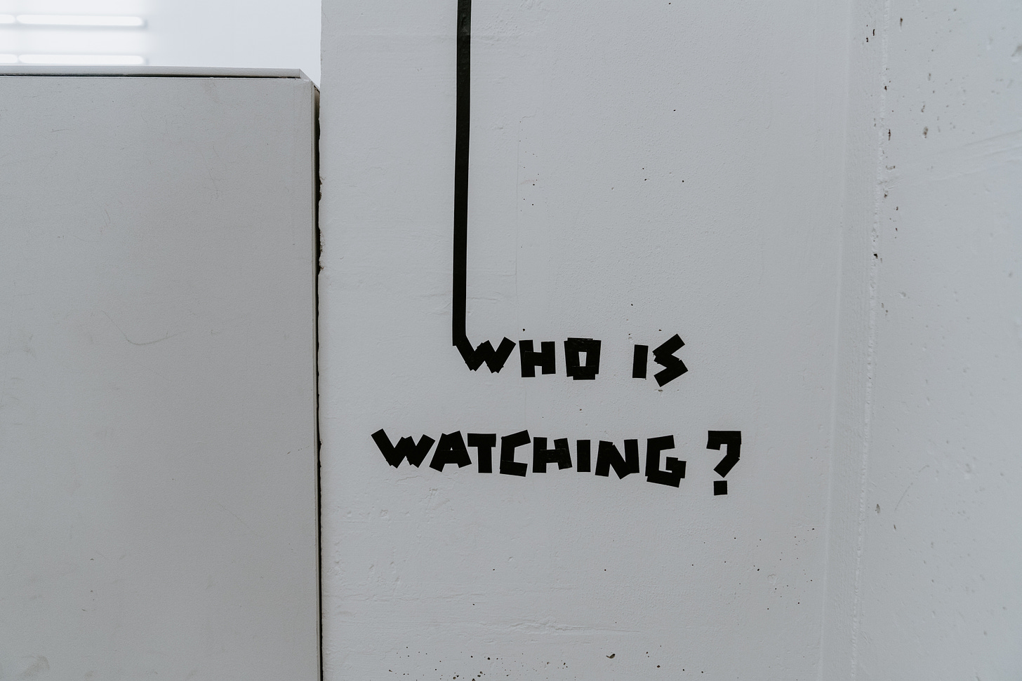 A picture of Who is Watching? painted on a wall