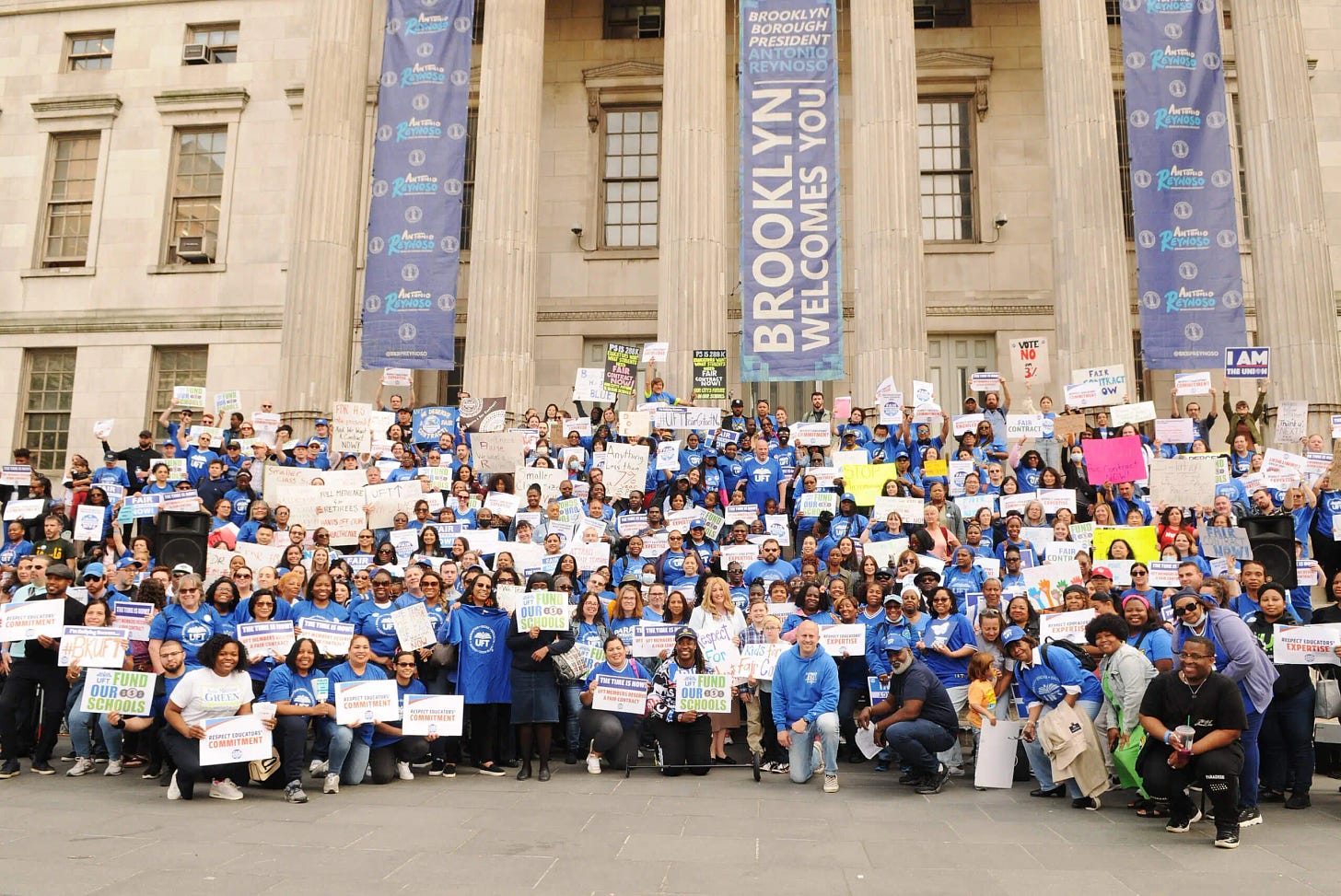 Hundreds of UFT members holding signs demanding a fair contract in front of the Brooklyn Borough Hall building.