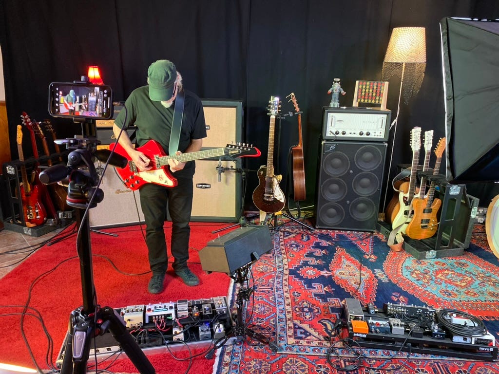 Filming a man playing guitar in a studio