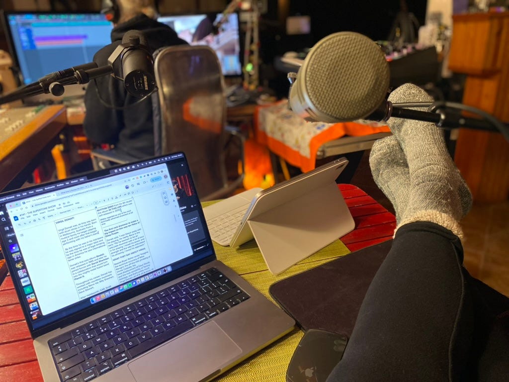 A computer and legs on a desk recording The Supertone Show podcast