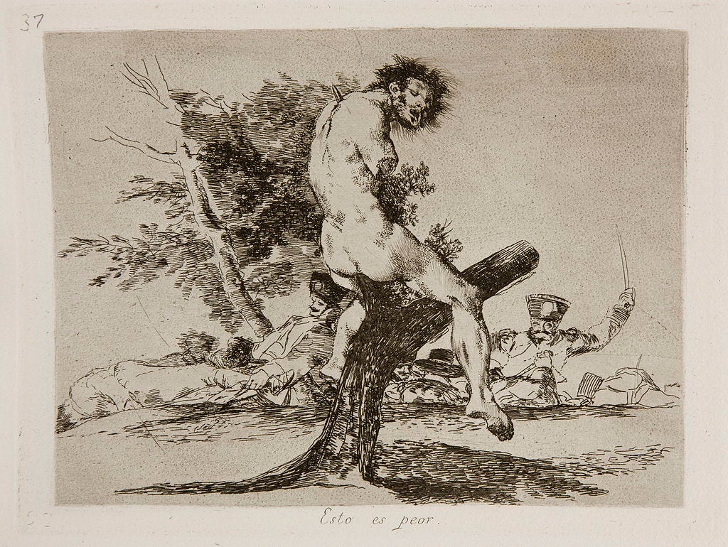 A dismembered and mutilated corpse is impaled on the branches of a tree A dismembered and mutilated corpse is impaled on the branches of a tree
