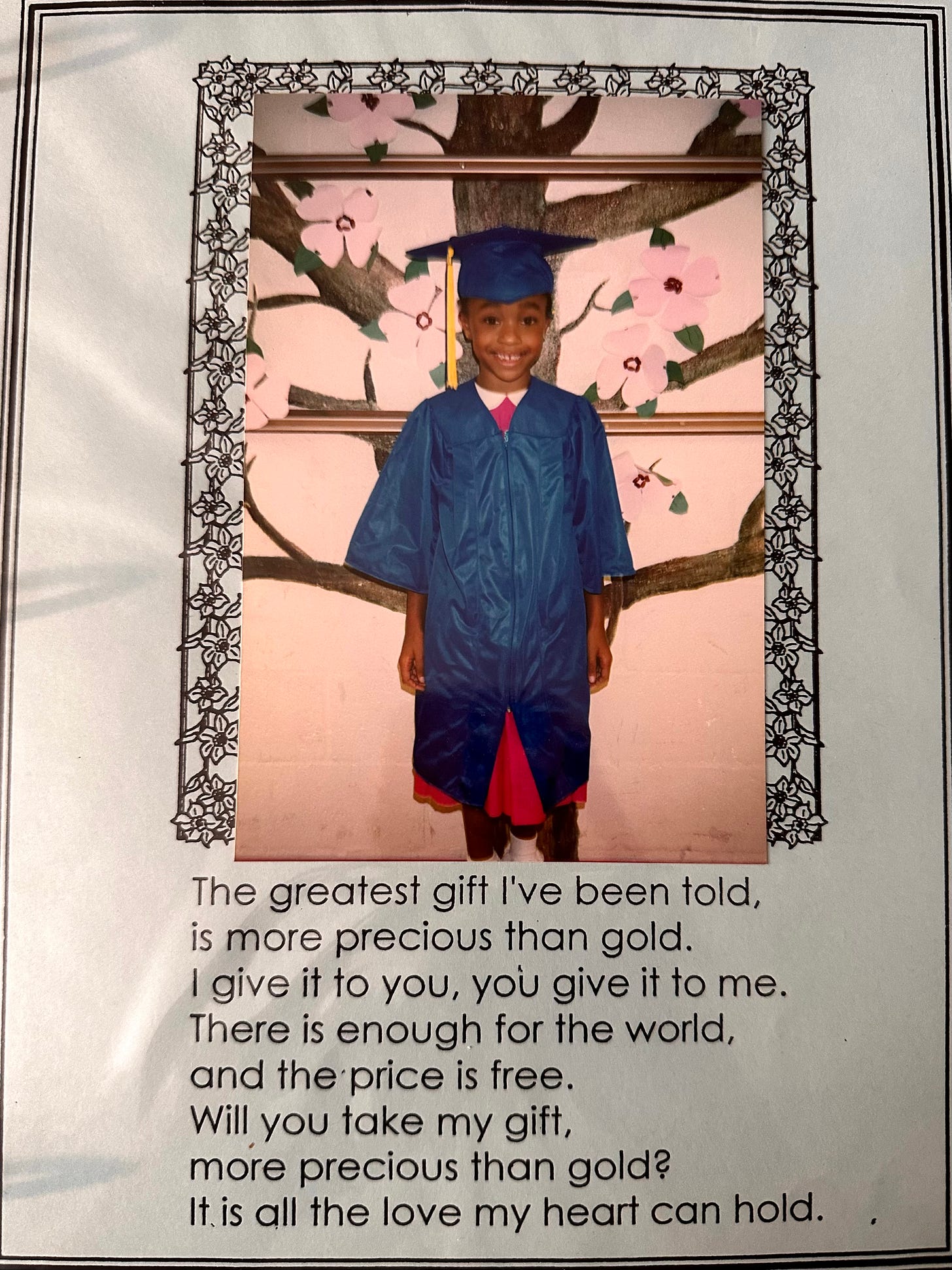 Little black girl smiling in blue cap and gown, graduating kindergarten