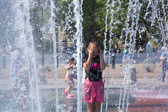 A girl cooling off in a fountain
