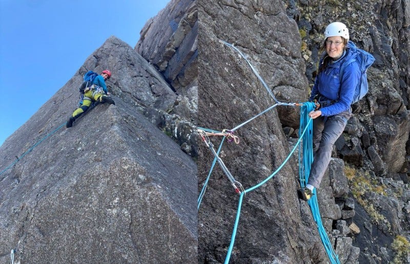Collage of two photos. the left shows a man climbing a featureless rib of rock, wearing bright yellow trousers, a blue jacket and rucksack, and a red helmet. He is looking down towards the camera. The right shows a woman attached to rocks with ropes and slings with excess rope draped in front of her. She is holding the rope that is going towards the viewer. She is smiling and looking at the camera. Collage of two photos. the left shows a man climbing a featureless rib of rock, wearing bright yellow trousers, a blue jacket and rucksack, and a red helmet. He is looking down towards the camera. The right shows a woman attached to rocks with ropes and slings with excess rope draped in front of her. She is holding the rope that is going towards the viewer. She is smiling and looking at the camera.