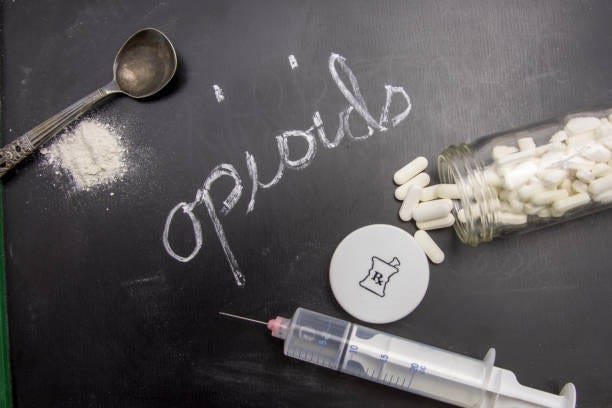 Opioids Opioids written in chalk on blackboard with crushed powder, spoon, syring and prescription vial. opioid dependency stock pictures, royalty-free photos & images