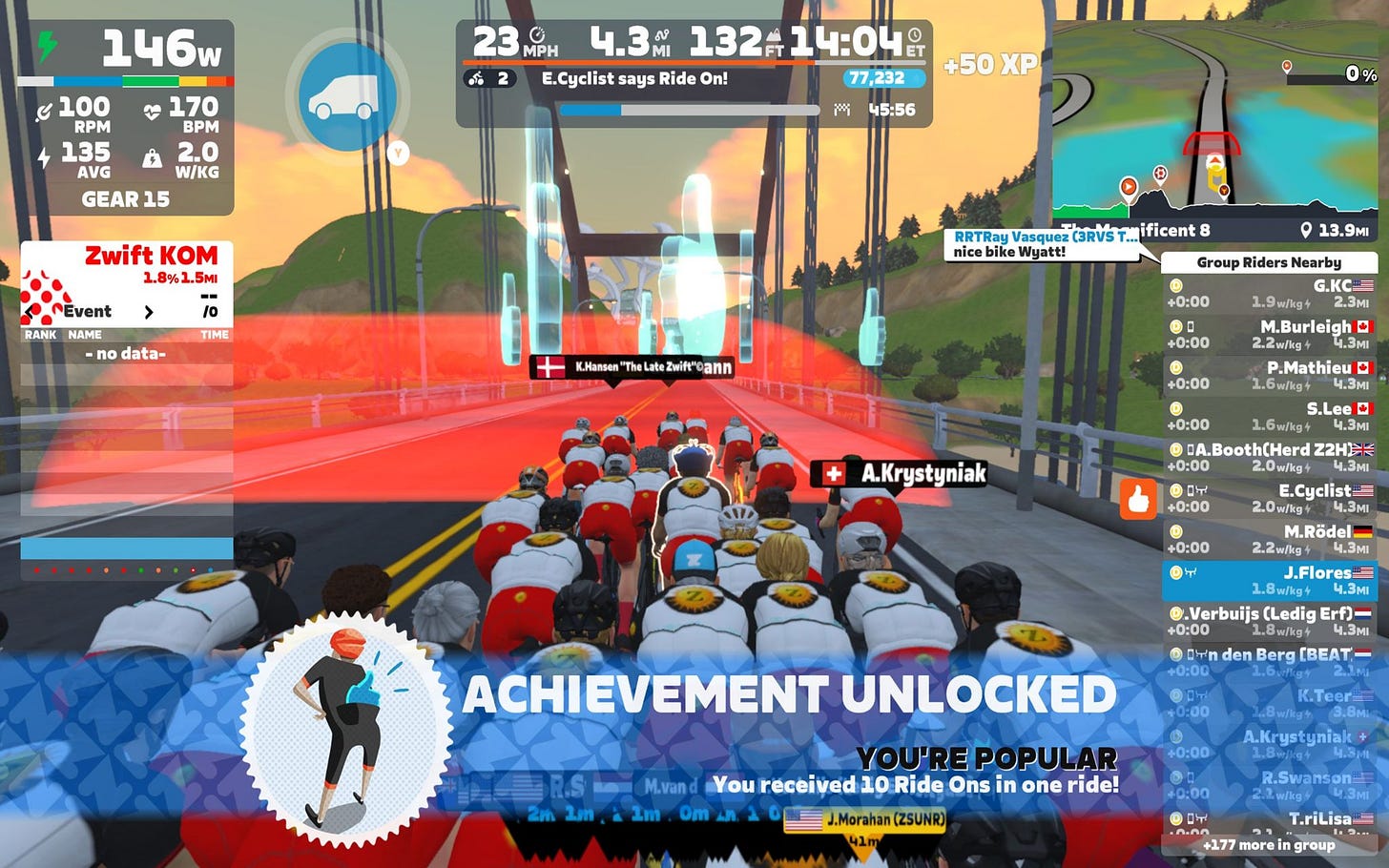 Zwift screen cap showing 20-30 riders riding over a suspension bridge. Ahead of the is a translucent red blob.