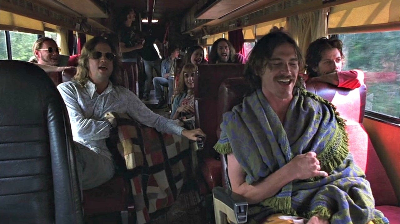 The Almost Famous characters in their tour bus during the "Tiny Dancer" scene.