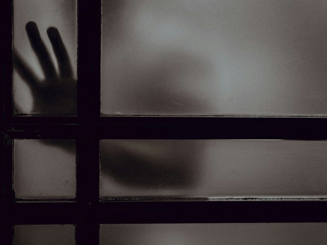 person touching frosted glass door