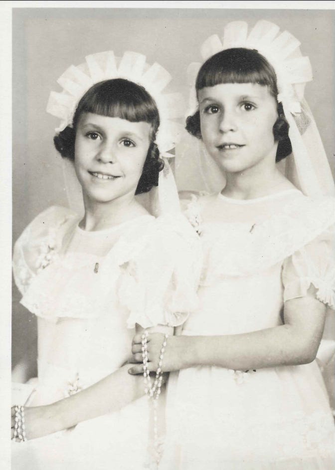 twin girls wearing white dresses and headbands posing for a photo