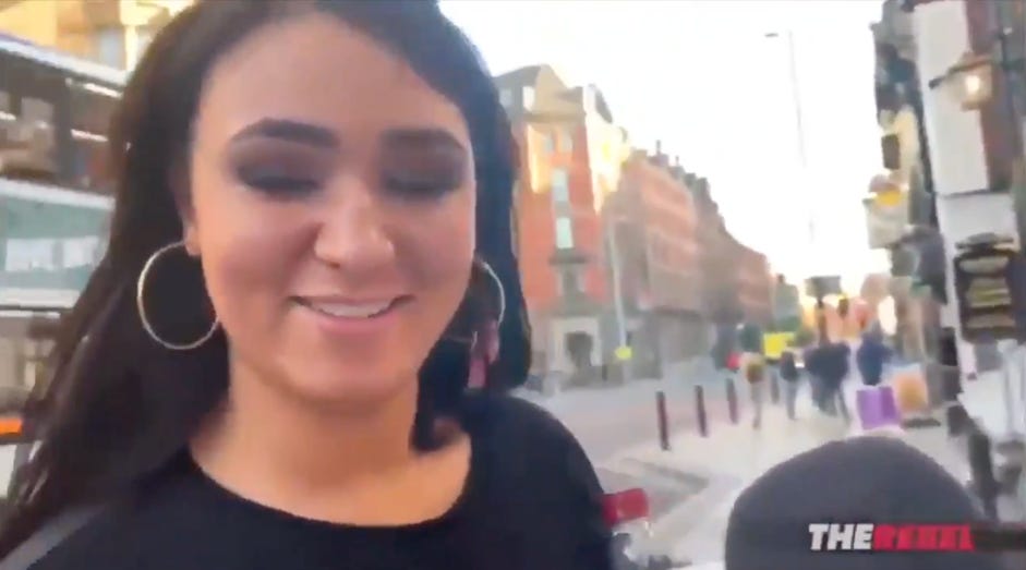 A person smiling in a city

Description automatically generated