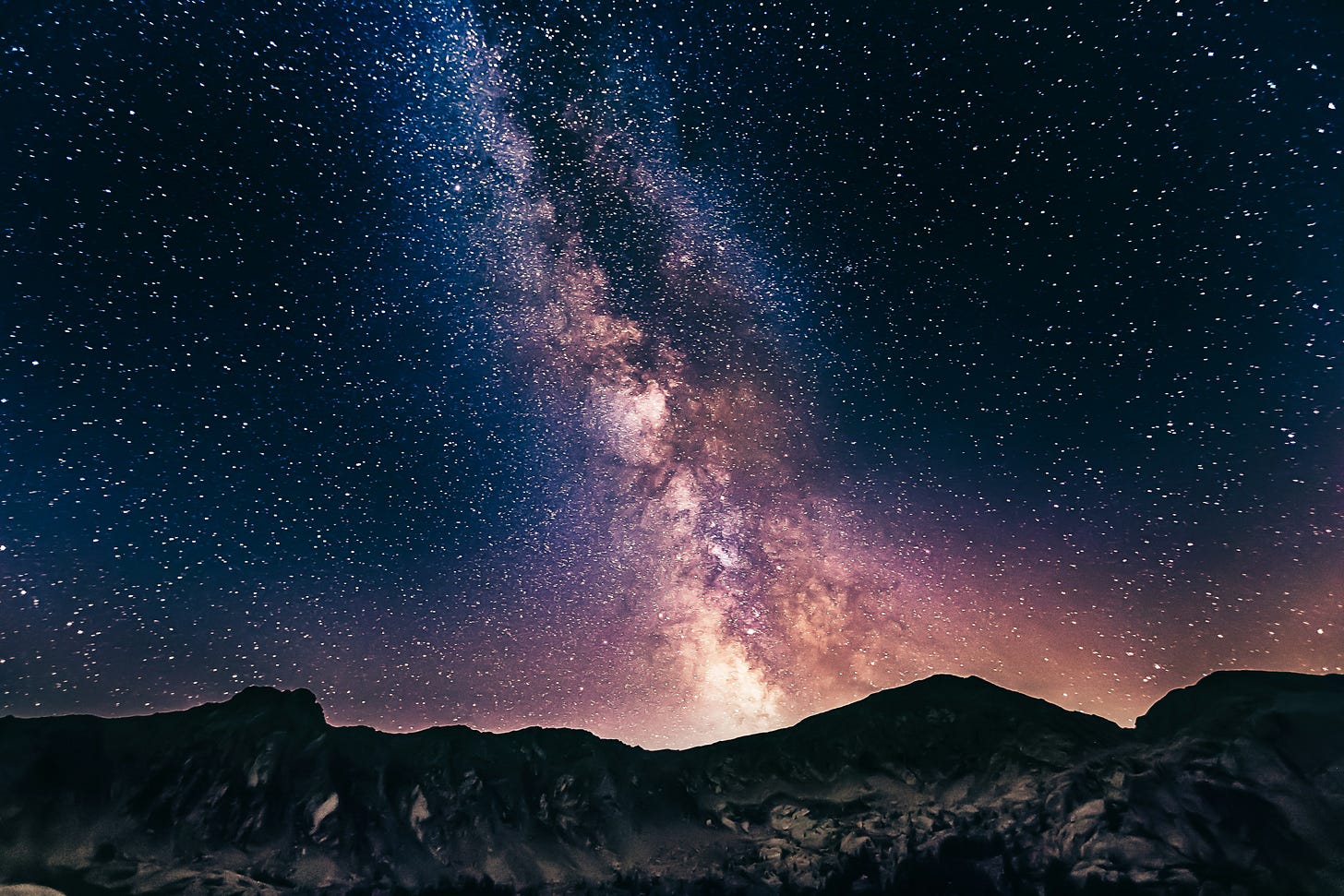 The pink and purple milky way above mountains The pink and purple milky way above mountains