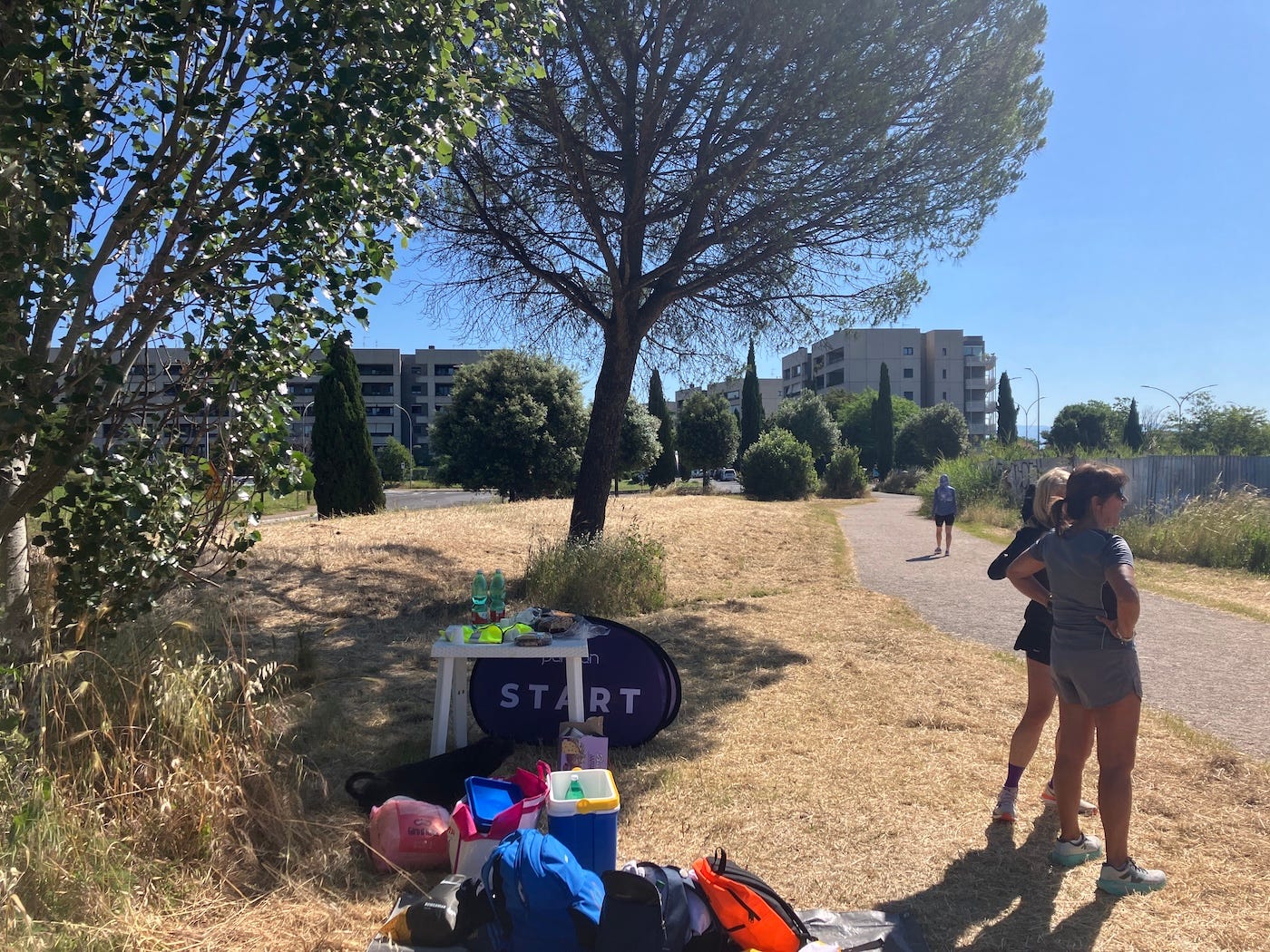A table by the finish line with water, in the shade